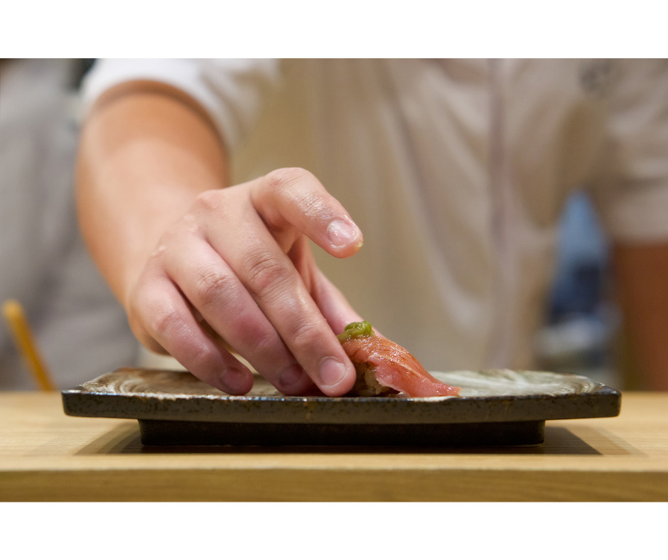 Sushi chef serving sushi at the counter