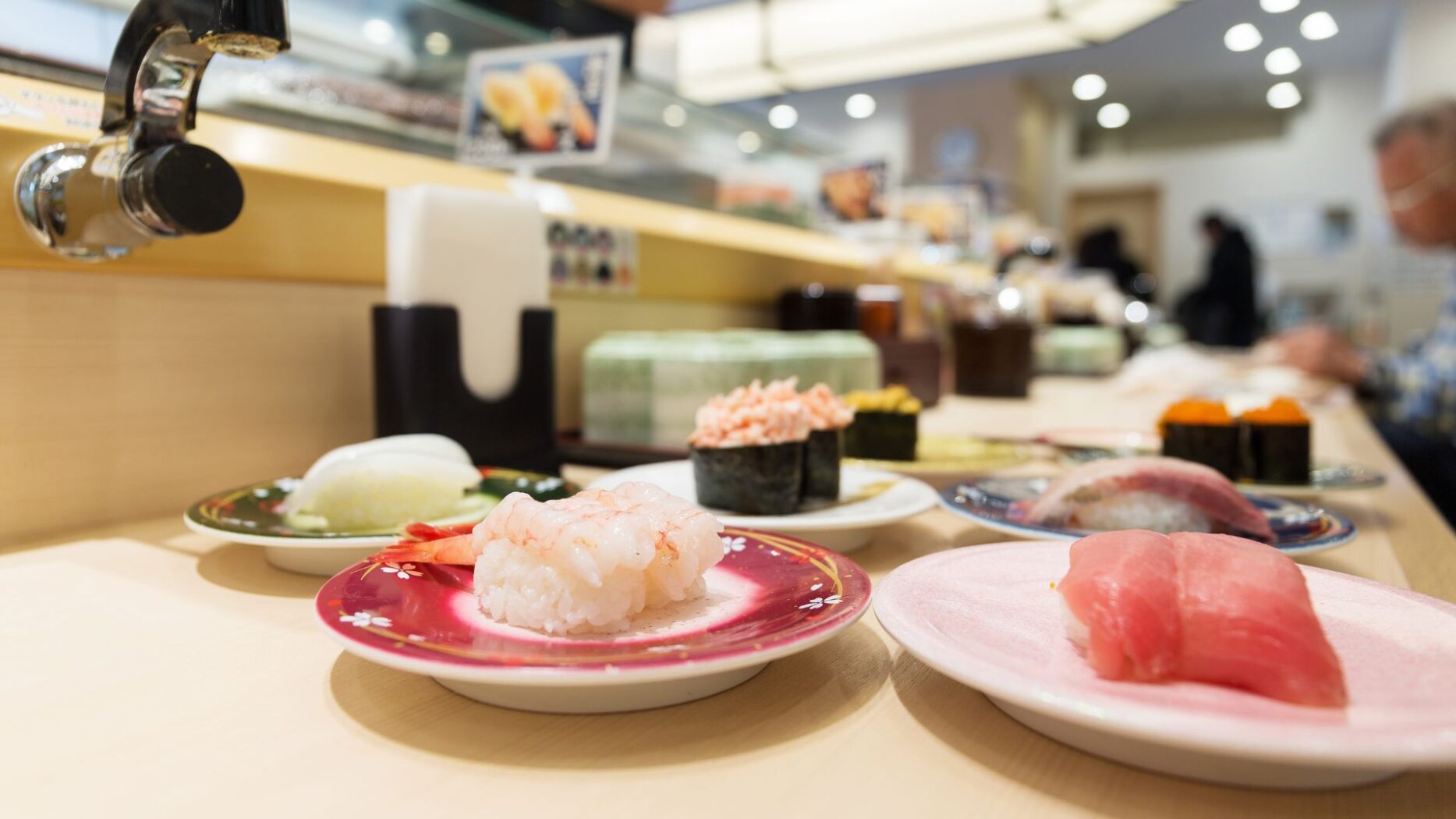 Sushi lined up on a conveyor belt sushi table