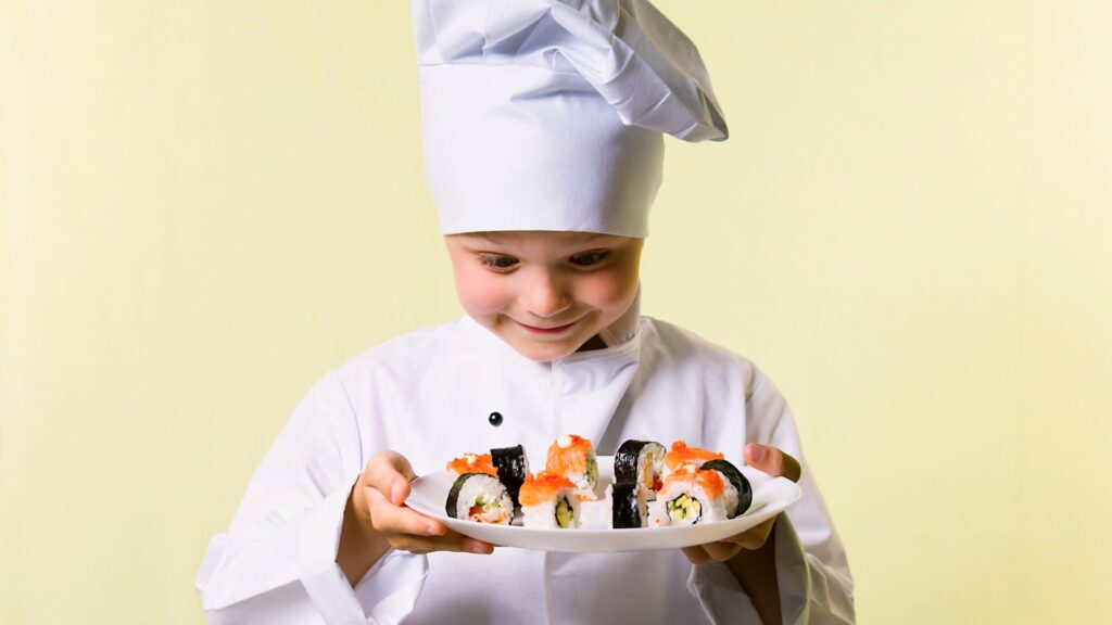 Foreign child sushi chef holding a plate of sushi