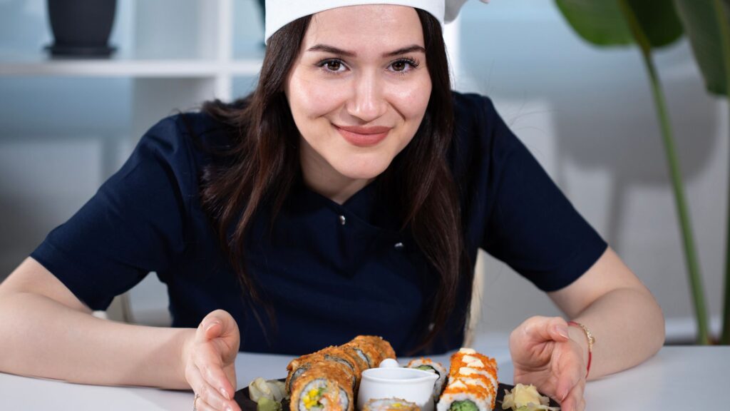 Foreign female sushi chef serving sushi