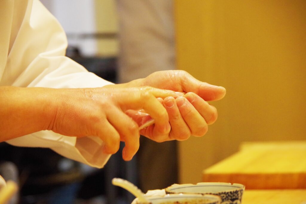 At the hands of a sushi chef